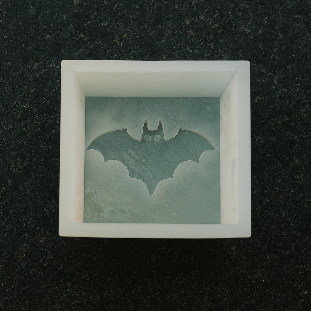 Square silicone ice mold with a bat design on a dark background