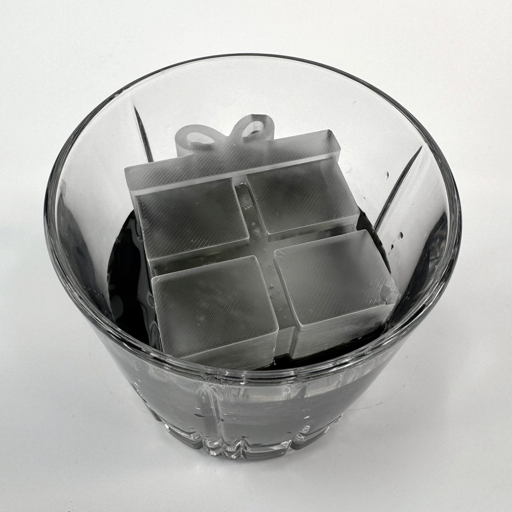 Silicone ice cube tray in a glass of water on a white background