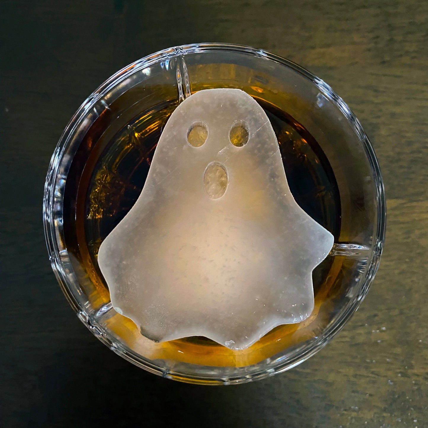 An ice mold in the shape of a ghost placed inside a glass of beverage, with a 'BOO!' text overlay.