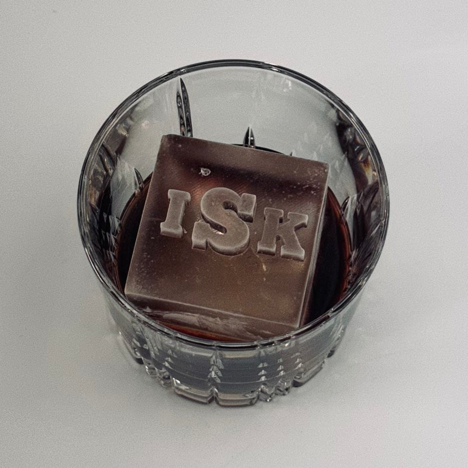 Ice cube with 'ISK' branding in a glass container on a white background