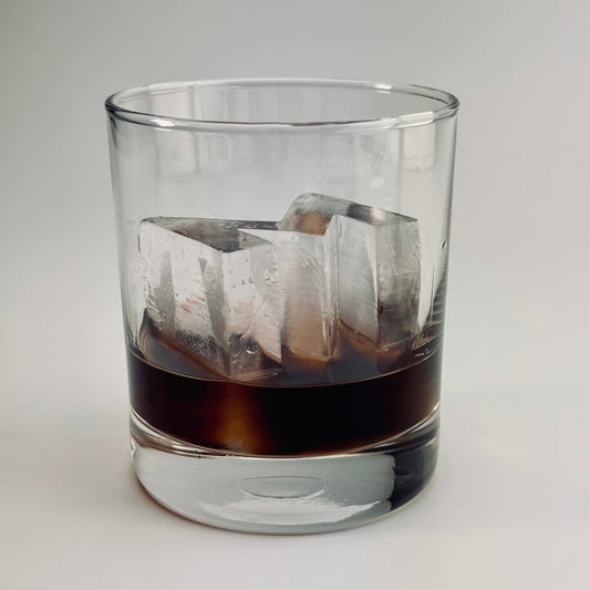 Frozen letter M ice in double Old Fashioned whiskey glass