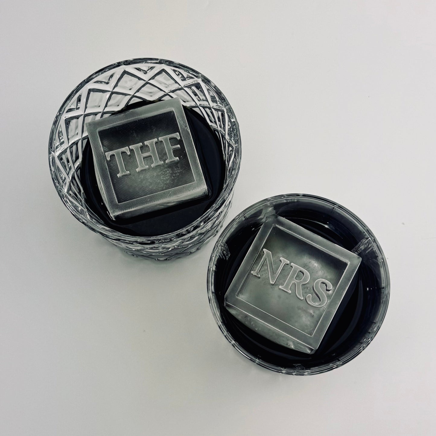Two black containers with ice cubes labeled 'THF' and 'NRS' on a white background.