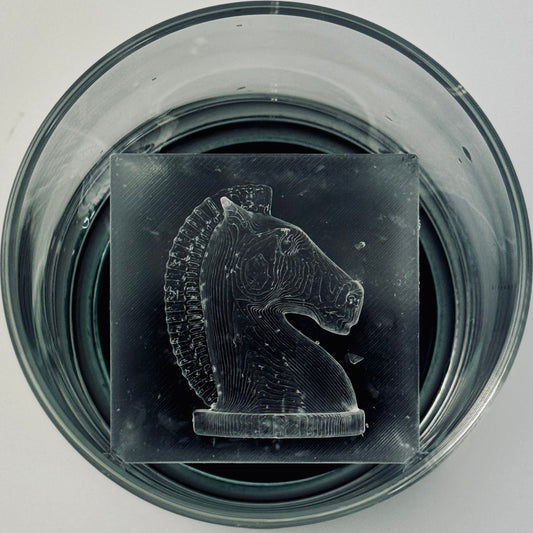 Ice Knight chess piece in a glass container on a light gray background