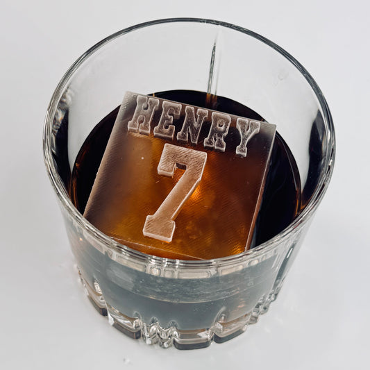 Clear glass with clear ice cube with 'HENRY 7'  on top
