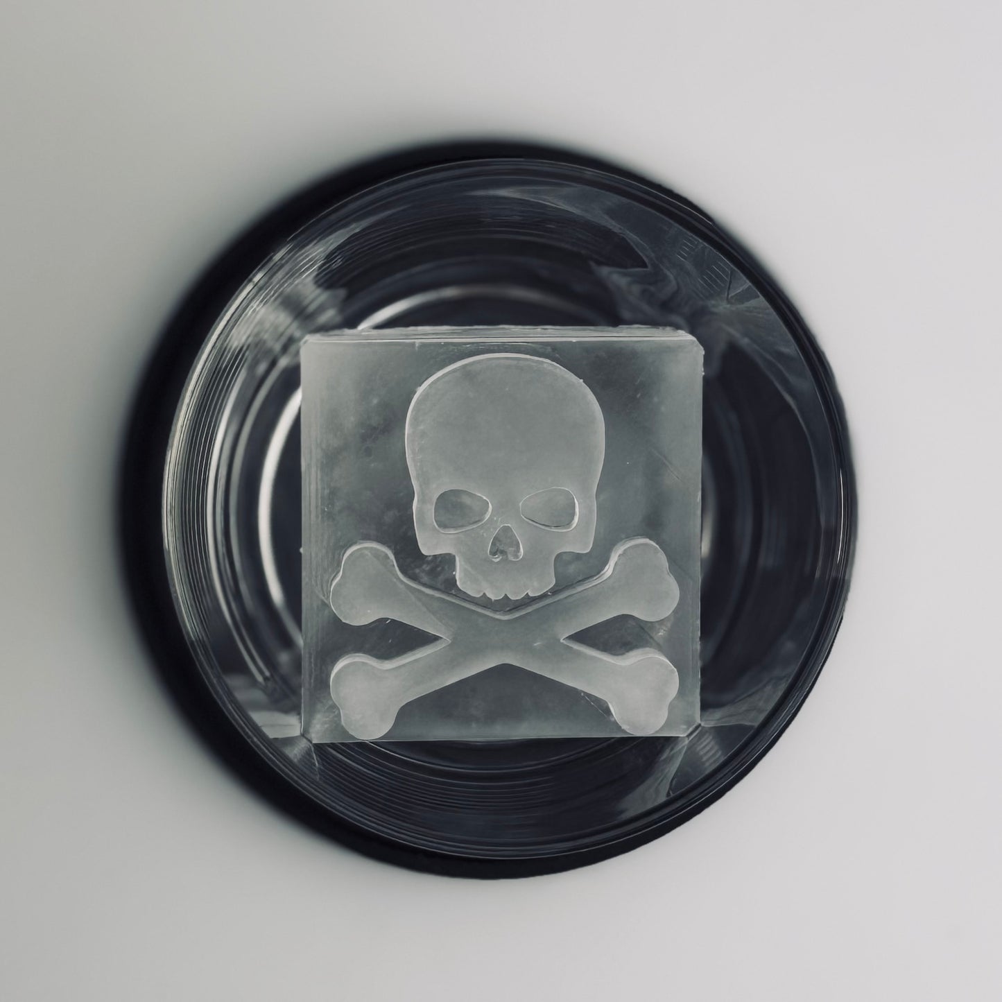 Cocktail glass with skull and crossbones design on a gray background