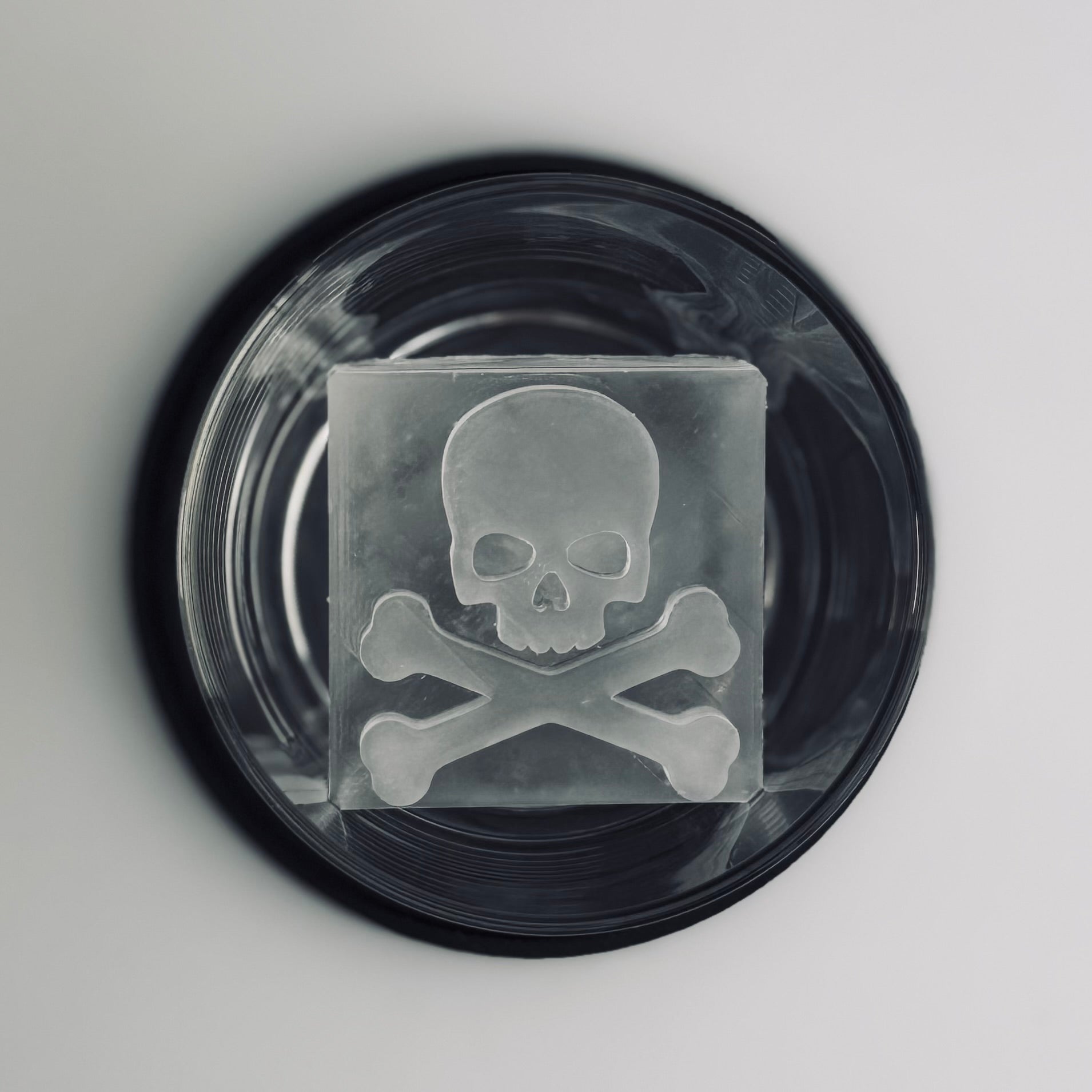 Cocktail glass with skull and crossbones design on a gray background