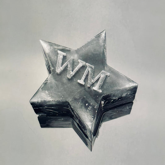 star-shaped ice with 'WM' initials on a gray background